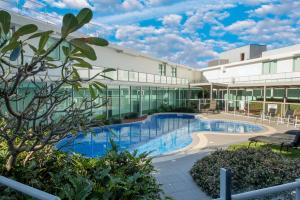 a large building with a swimming pool in front of it at Modern 2 Bedroom Apt near Tram & Ocean in Gold Coast