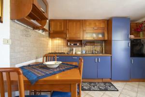 a kitchen with blue cabinets and a wooden table at Casetta Brandinu in Sassari