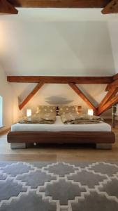 uma cama num quarto com tecto em madeira em Sägemühle Eschachthal em Buchenberg