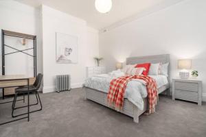 een witte slaapkamer met een bed en een bureau bij luxury city living - private entrance-free parking in Hobart
