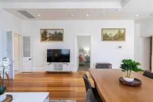 een woonkamer met een tafel en een flatscreen-tv bij luxury city living - private entrance-free parking in Hobart