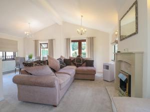 a living room with a couch and a fireplace at 27 Brocklehurst in Oakham