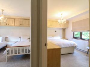 a bedroom with two beds and a desk at 27 Brocklehurst in Oakham