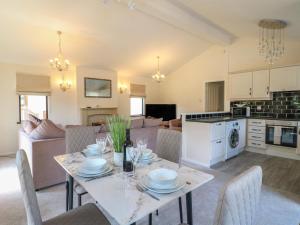 uma cozinha e sala de estar com mesa e cadeiras em 27 Brocklehurst em Oakham