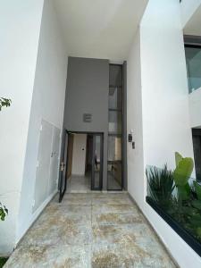 a hallway of a building with white walls and glass doors at Étoile Harhoura in El Harhoura