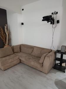 a brown couch in a living room with a table at LuxHoliday Apartment in Carpignano Salentino