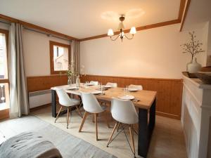 ein Esszimmer mit einem Holztisch und weißen Stühlen in der Unterkunft Duplex rénové 4 pièces, 6 pers., 2 balcons, casier à skis, ménage inclus - FR-1-291-791 in Valmorel + 4 Fotos