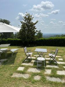 a group of picnic tables and chairs in the grass at Bellaveduta Holidays Home in Baldissero Torinese