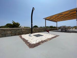 a patio with a stone wall and a street light at Bluebell Resort Villa SUNSET in Kampos Paros