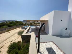 ein weißes Haus mit einem Dach in der Unterkunft Bluebell Resort Villa SUNSET in Kampos Paros