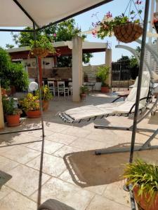 a patio with lounge chairs and an umbrella at La pomelia in Casa Di Natale