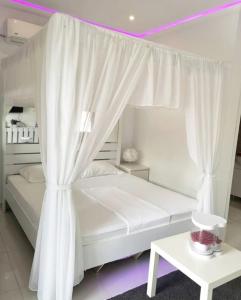 a white bed with a canopy in a room at Gaia Aparthotel in Constanţa