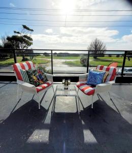 two chairs and a coffee table on a balcony with a view at Waters Edge Apartment in Rye