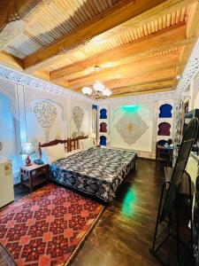 ein Schlafzimmer mit einem Bett und einem Teppich in einem Zimmer in der Unterkunft Komil Bukhara Boutique Hotel in Buxoro