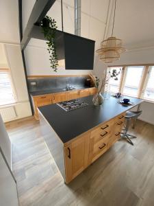una cocina con una isla con encimera negra en Appartement Oldenburg, en Bergen