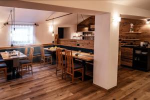 ファルツェスにあるAppartement- und Wellnesshotel Winklerのテーブルと椅子が備わるウッドフロアのレストランを併設しています。