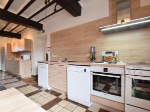 uma grande cozinha com electrodomésticos brancos e paredes de madeira em Luxury Holiday Home in Melreux Hotton with Sauna em Melreux