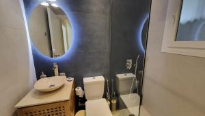 a bathroom with a toilet and a sink and a mirror at Elegant Apartment For 4 Ppl In P. Faliro in Athens