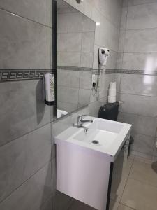 a bathroom with a white sink and a mirror at Hotel Albergo in Brussels