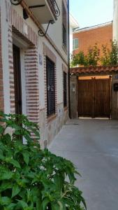 a building with a gate and a courtyard with a garage at La plazuela Navaluenga in Navaluenga