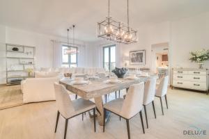 a dining room and living room with a table and chairs at Peaceful 4BR Penthouse with Assistant Room at Le Pont Jumeirah by Deluxe Holiday Homes in Dubai