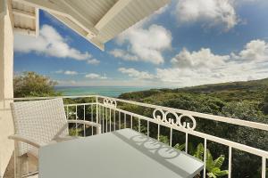 balcón con mesa y vistas al océano en Fantaisie Lodges, en Rodrigues Island