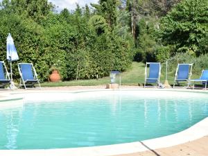 a swimming pool with two chairs and a swimming pool at Restful Farmhouse near Forest in Vinci with Pool in Vinci