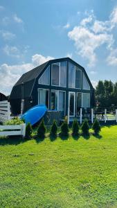 ein großes Haus mit einem blauen Surfbrett davor in der Unterkunft Saulėlydis in Dreverna