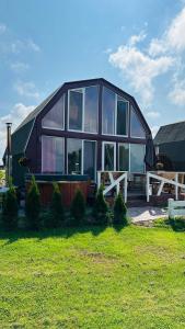 Casa grande con ventanas grandes en un campo de césped en Saulėlydis en Dreverna