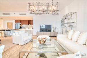 a living room with a white couch and a glass table at Peaceful 4BR Penthouse with Assistant Room at Le Pont Jumeirah by Deluxe Holiday Homes in Dubai