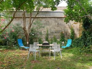 a table and chairs in a yard next to a wall at Maison 150m2 jardin à louer en entier, Bordeaux centre Chartrons, 3 Chambres 3 Salles de bains 1 canapé-lit llllnuméro de téléphone dans l'annonce si questionlll in Bordeaux