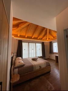 a bedroom with a bed with a wooden ceiling at C’era una volta un Re… in Calalzo