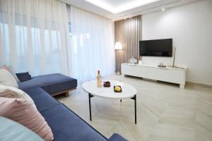 a living room with a blue couch and a table at Horizon Seaside Living in Iraklitsa