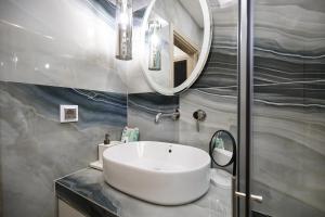 a bathroom with a white sink and a mirror at Horizon Seaside Living in Iraklitsa +13 photos