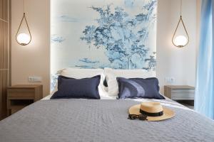 a hat and sunglasses sitting on top of a bed at Horizon Seaside Living in Iraklitsa