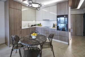 a dining room with a table and chairs and a kitchen at Horizon Seaside Living in Iraklitsa