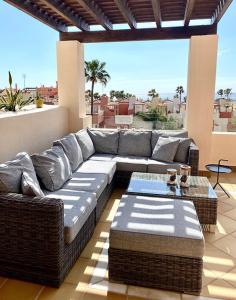 ein Wohnzimmer mit einem Sofa und einem Tisch auf einer Terrasse in der Unterkunft Bahía Boutique Apartments in Estepona