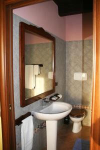 a bathroom with a sink and a toilet and a mirror at Agriturismo Cascina la Palazzina in Albairate