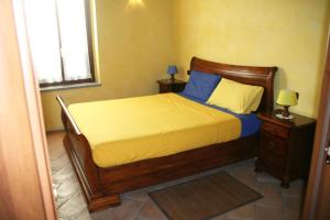 um quarto com uma cama com lençóis azuis e amarelos em Agriturismo Cascina la Palazzina em Albairate