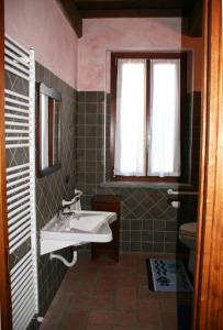 baño con lavabo y ventana en Agriturismo Cascina la Palazzina, en Albairate