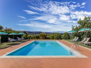 una piscina con 2 sillas y sombrillas en Countryside Holiday Home in Gambassi Terme with Garden, en Querce