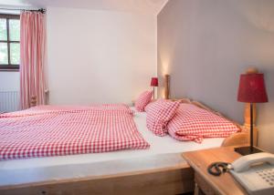 Boutique-Hotel Weigels Bergfreiheit في وينتربرغ: غرفة نوم بسرير ومخدات حمراء وبيضاء