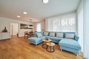 a living room with a blue couch and a table at Parkblick Bad Driburg in Bad Driburg