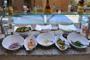 uma vitrine com tigelas de diferentes tipos de alimentos em Royal Bay Resort - All Inclusive and Free beach accsess em Balchik