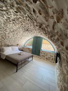 1 dormitorio con 1 cama en una pared de piedra en Mainotti's house, en Areopoli