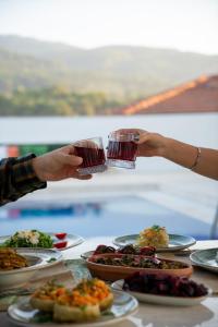 two people holding up glasses of food on a table at B&Y Burgaz in Selcuk