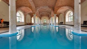 a swimming pool in a building with columns at Pałac Wiechlice in Szprotawa