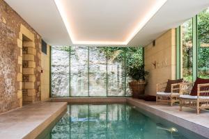 a pool in the middle of a house with glass walls at Hôtel de Bouilhac in Montignac