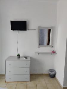 a bedroom with a dresser and a tv on the wall at Eva's Home in Skala Kallirakhis +15 photos