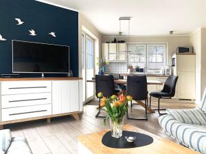 a living room with a tv and a couch and a table at Ferienhaus Am Strand in Zingst